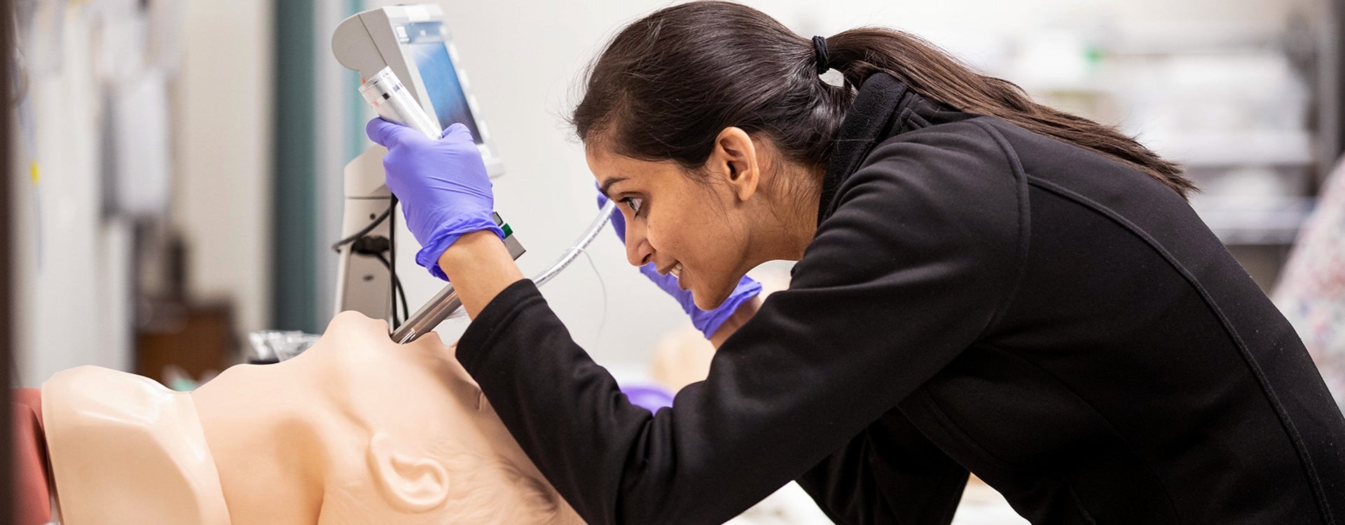 A female Brody School of Medicine student practices intubation techniques using a manikin.