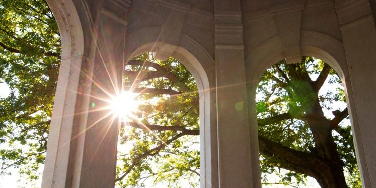 Cupola sunrise with rays of morning sun peaking through the trees.